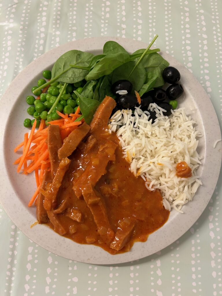 Tallrik med skollunch bestående av korvstroganoff, ris och grönsaker